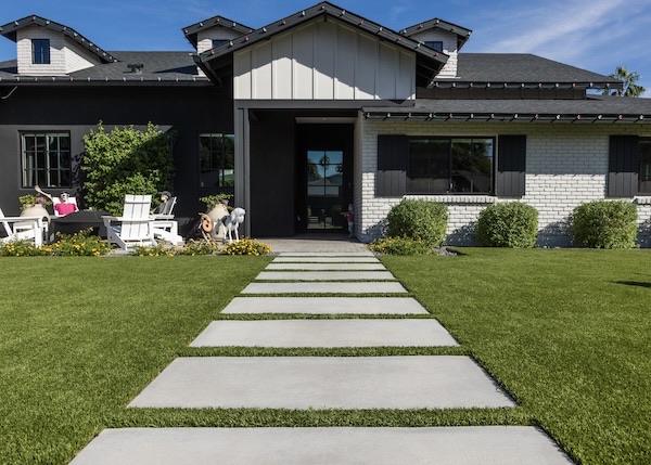 Concrete paver walkway through a freshly mowed front lawn
